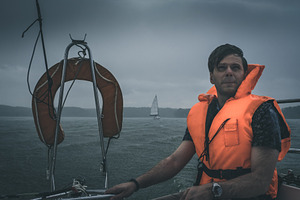 Male sailing under heavy rain
