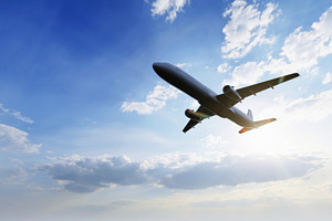 Airplane flying in the air with sunlight shining in blue sky background. Travel, a Transportation Photo by Ministocker