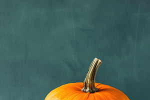 Minimal orange pumpkin on teal Halloween background, a Food & Drink Photo by José Manuel Gelpi