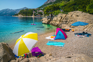 Amazing gravelly beach with parasols, a Holiday Photo by Alpine Dreams