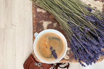 : Top view of a rustic wooden stool with a coffee cup and sprig