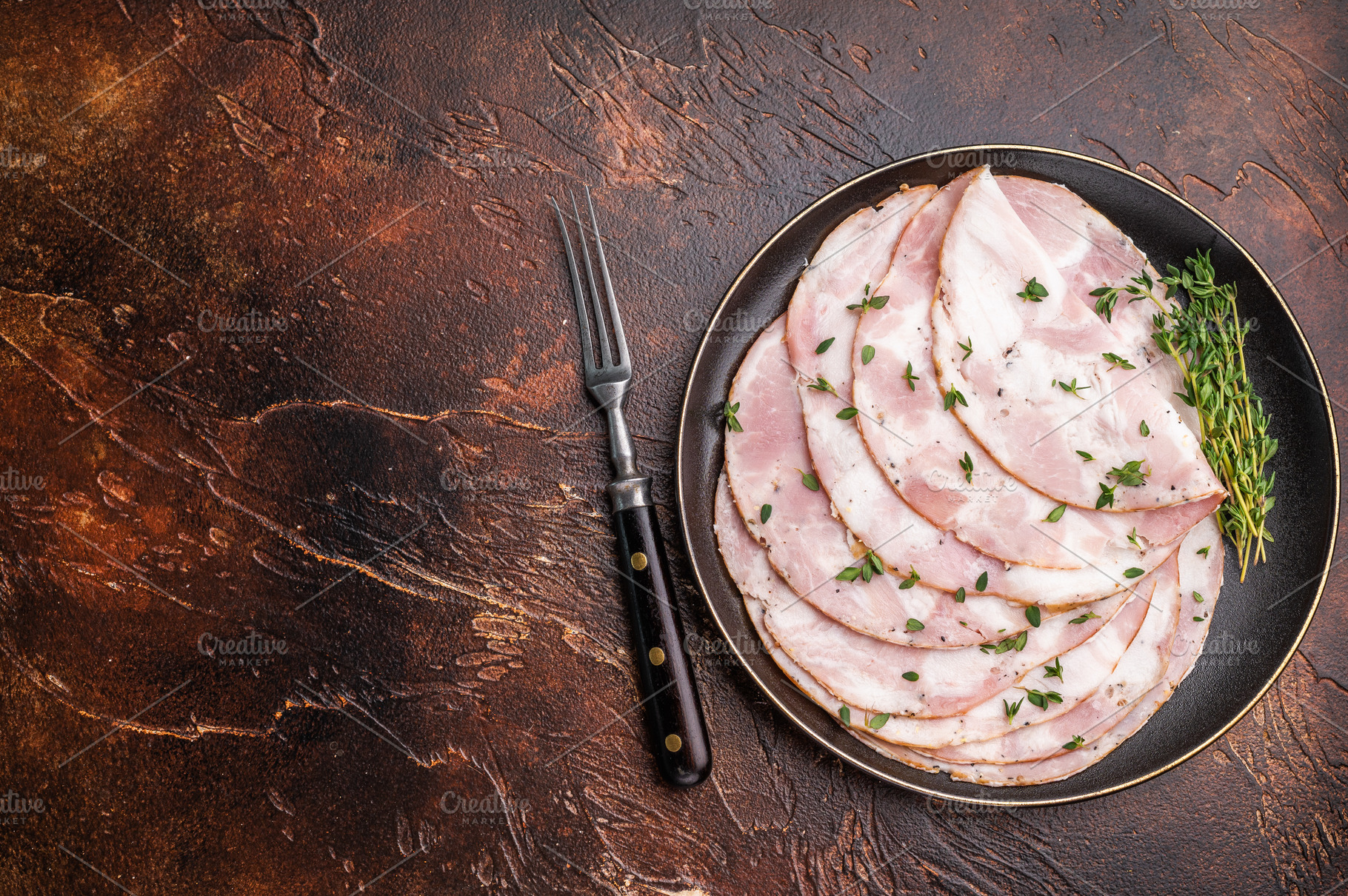 Slices of Italian Pancetta Arrotolata with thyme on a black plat, a Food & Drink Photo by composter-box@mail.ru