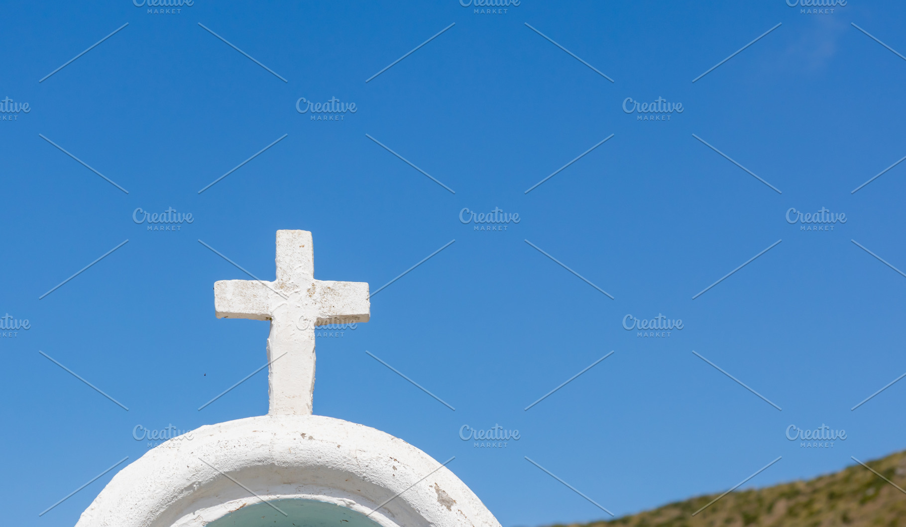 White cross standing on a roof under blue sky, a Photo by Antonio Gravante Market