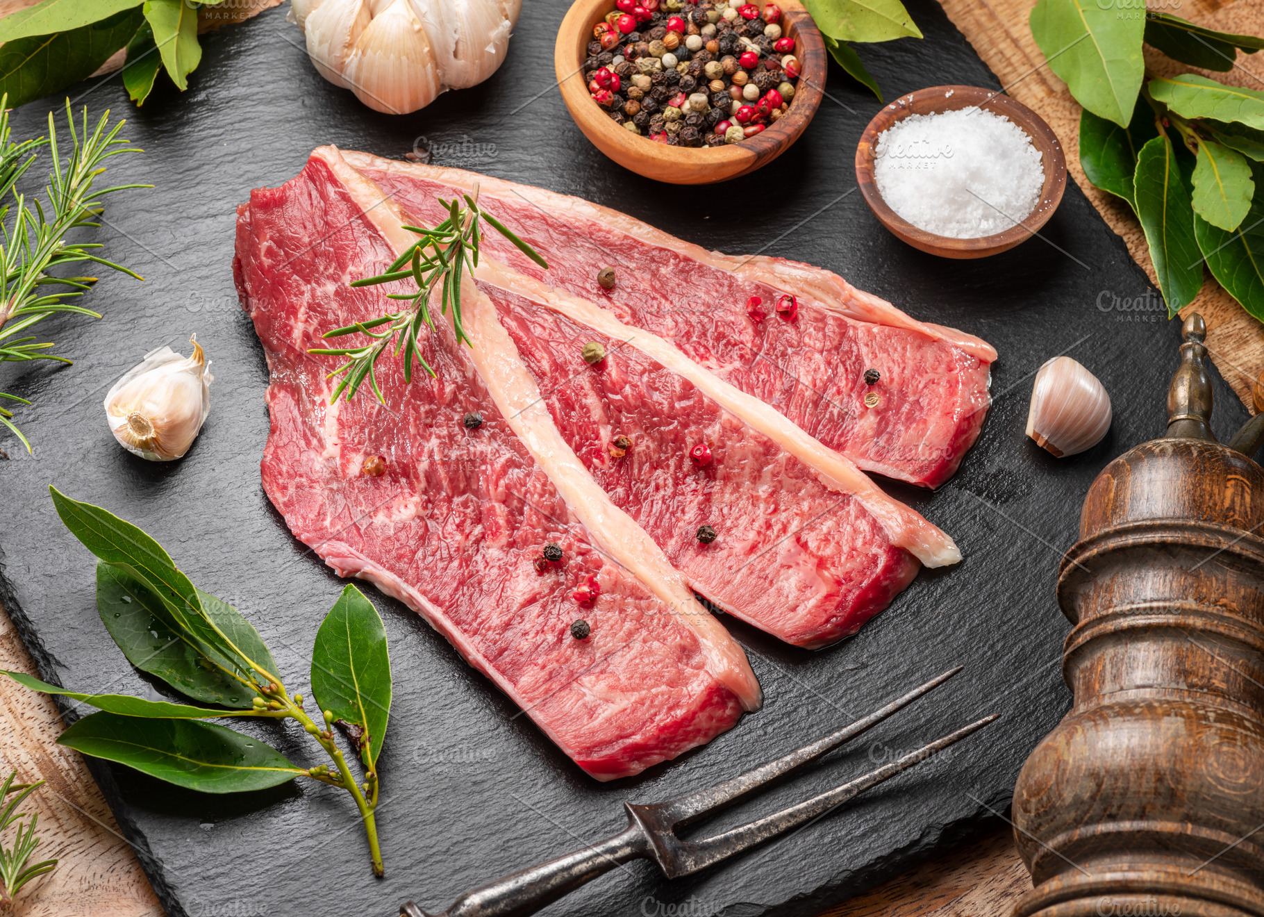 Sliced picanha beef with spices and herbs on a gray stone servin, a Food & Drink Photo by Volff
