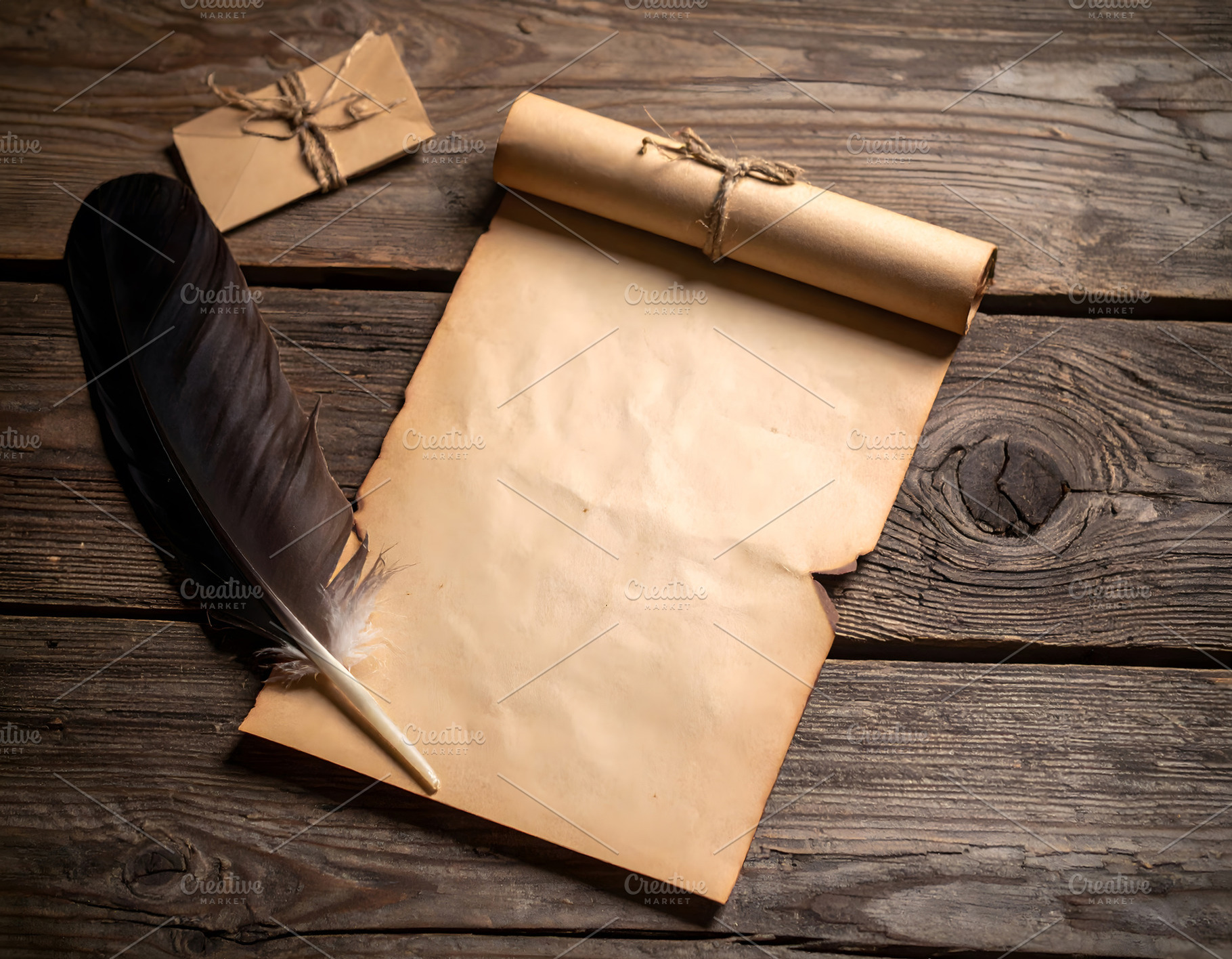 Rolled parchment with feather quill and tied letter nearby, a Holiday Photo by GoodGoods