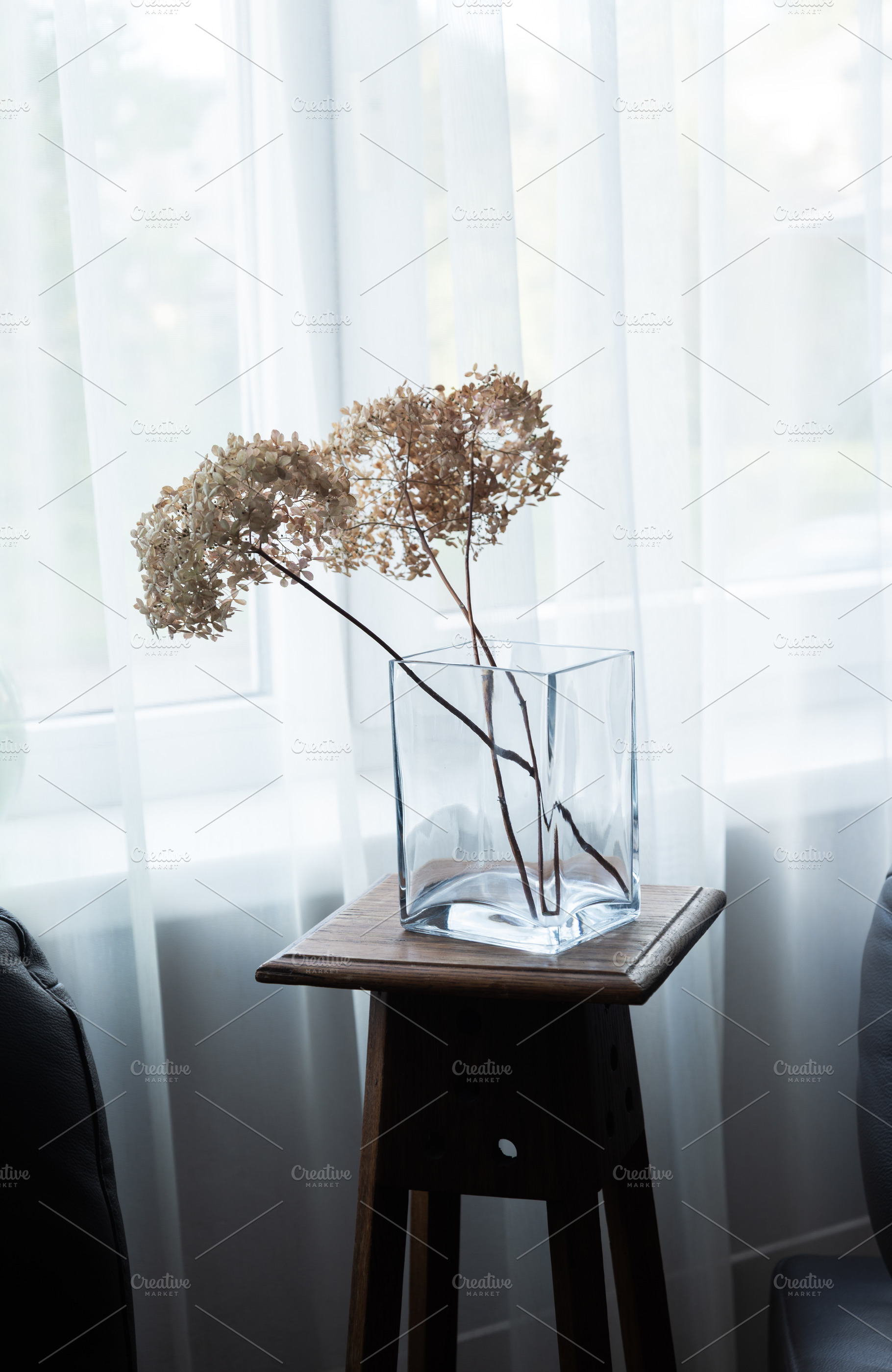 Glass vase with dried hydrangea flowers on wooden stool by windo, an Industrial Photo by MDBildes