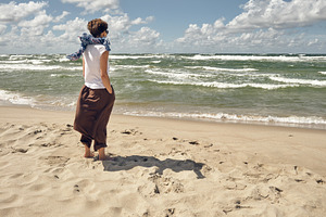 Lonely woman standing on the beach, a Person Photo by BOOCYS