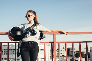 Young female biker holding motorcycle helmet stock photo containing girl and, a Person Photo by Aliaksei Kaponia