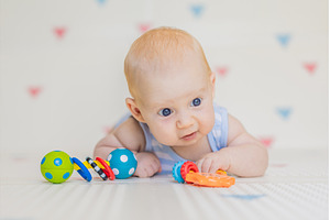 Adorable baby playing with colorful, a Background Photo by Elizaveta Galitskaya