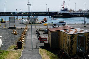 Seaside harbor view with industrial equipment and boats in Akranes, Iceland, a Photo by AS photostudio