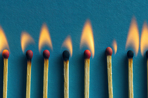 Burning matches against a blue, a Photo by Pavel_design