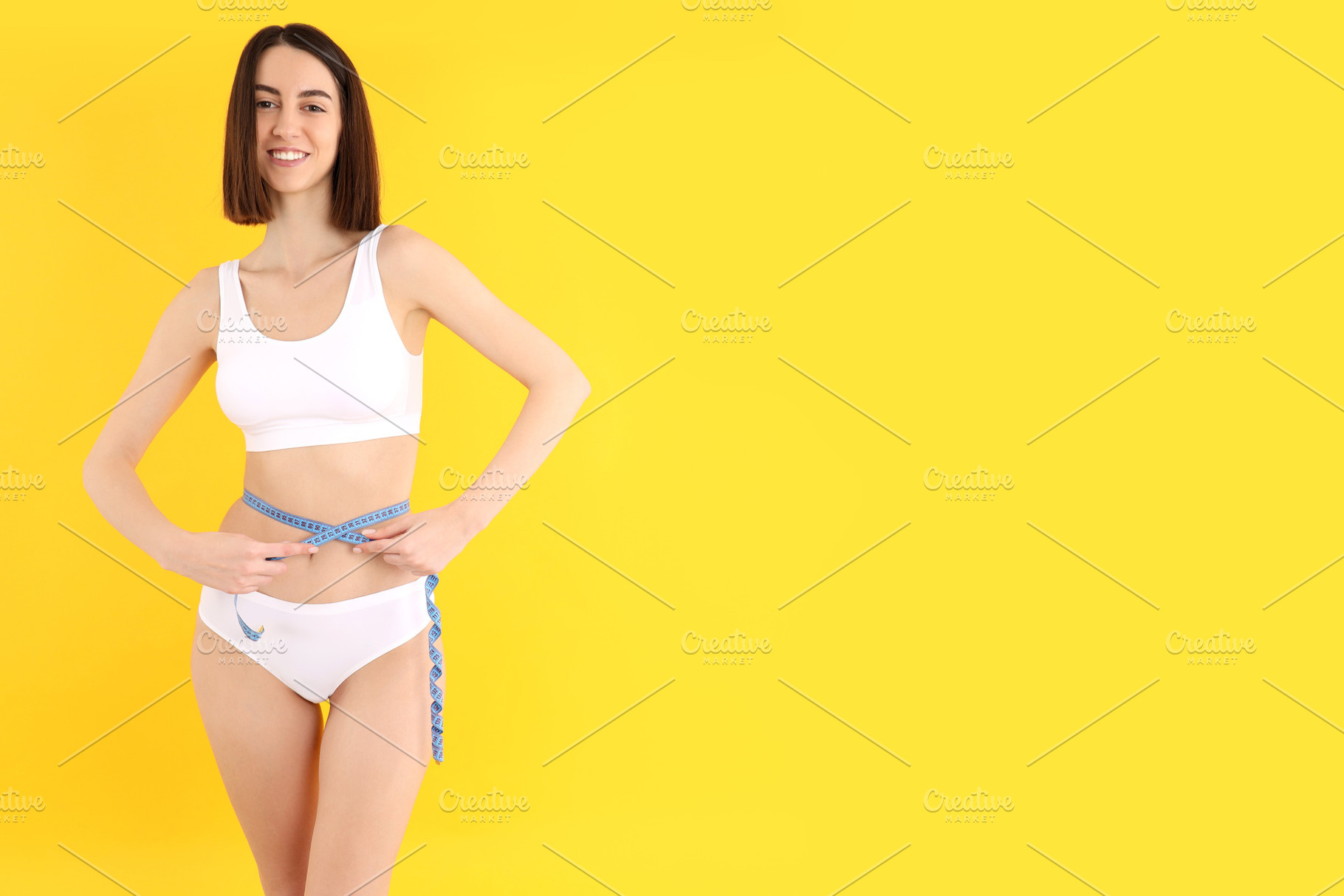 Concept of weight loss with young slim woman on yellow backgroun, a Person Photo by AtlasStudio