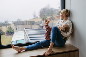 Mother breastfeeding her toddler son, a Person Photo by HalfPoint
