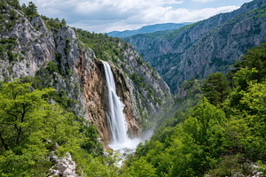 Majestic waterfall in a lush green valley, a Nature Photo by AlyaAnd