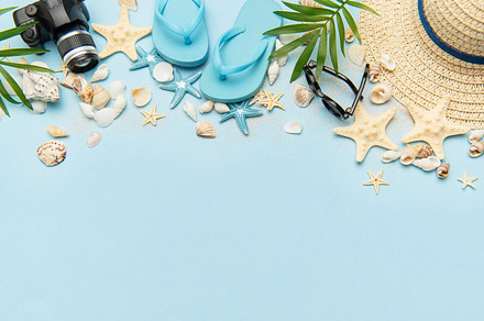 Summer accessories creating a frame on light blue background wit