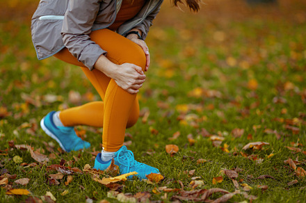 Trendy woman in fitness clothes in park got leg injury, a Sports & Recreation Photo by Alliance Images