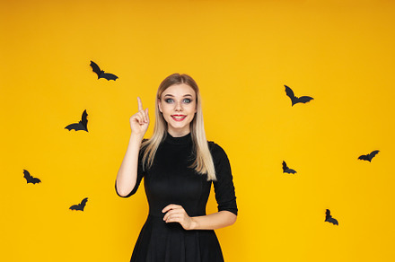 Concept of Halloween, young woman on yellow background, a Person Photo by AtlasStudio PRO