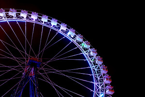 Part of ferris wheel with blue light containing ferris wheel, night, and wheel