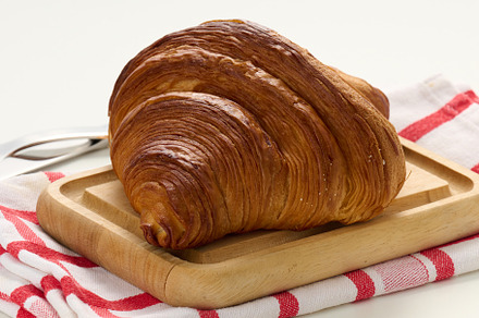 Baked crisp croissant on wooden board, white table. Breakfast, a Food & Drink Photo by ndanko