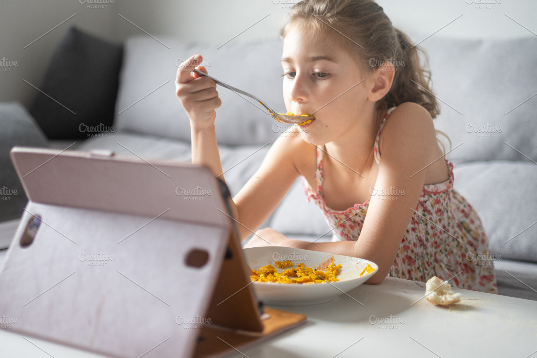 Young Girl Eating Lunch While Watching Tablet at Home, a Person Photo by etorres69