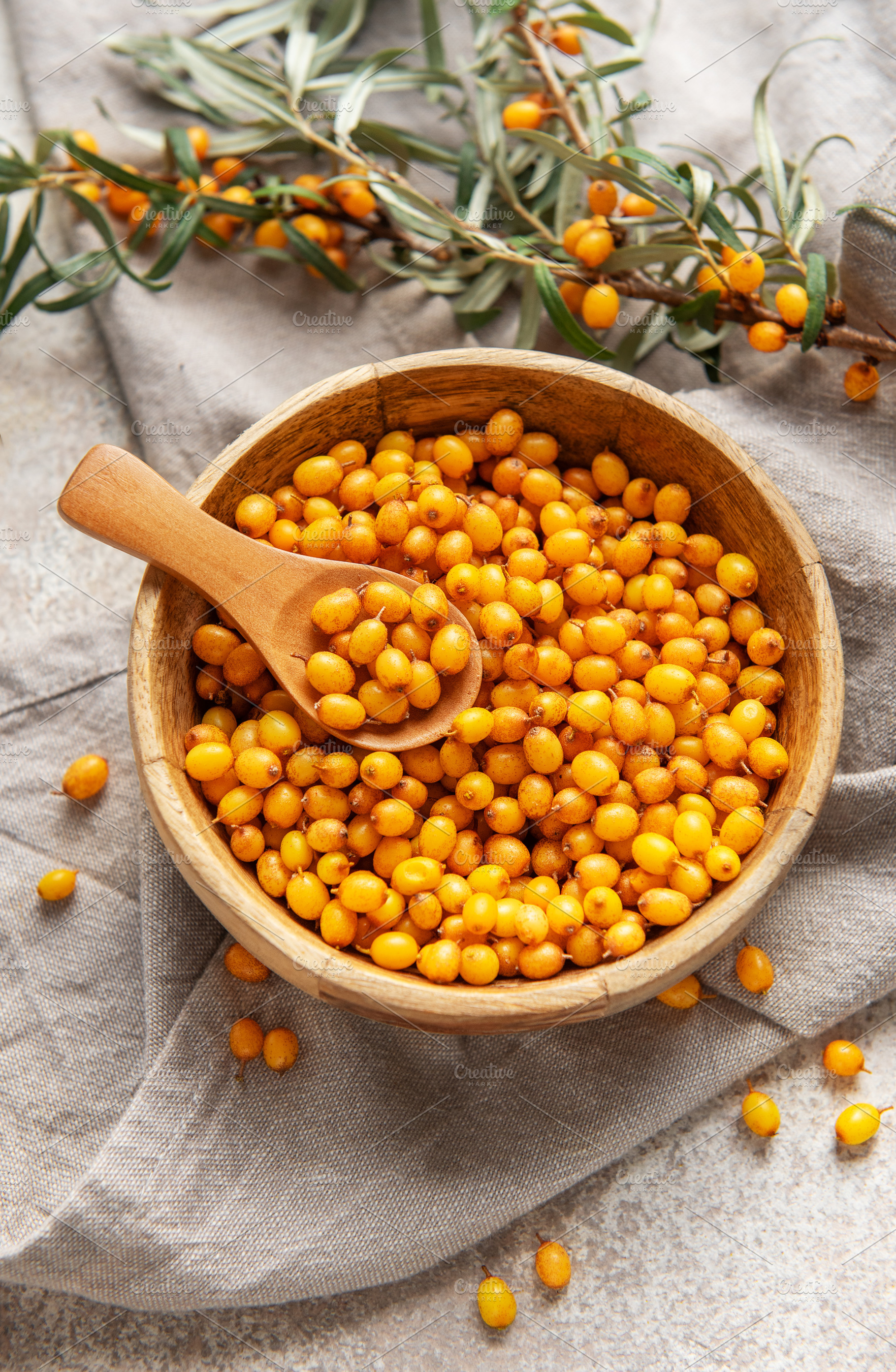 Sea buckthorn berries in wooden bowl, a Food & Drink Photo by Olena Rudo
