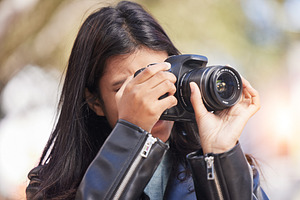 Nature, photography and woman in park with camera, trees, art and creative influencer with inspiration focus in media. Girl, photographer or content creator in garden taking picture for social media., a Photo by Peopleimages.com