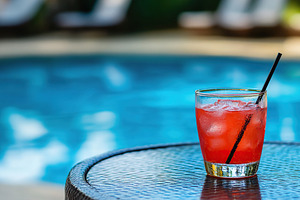 Refreshing cocktail served by a shimmering pool on a sunny day with colorful be, a Food & Drink Photo by AlyaAnd