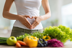 Woman making heart shape over stomach with fresh produce, a Food & Drink Photo by AlyaAnd