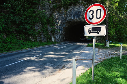 Road rocky tunnel with 30 speed limit sign in Bled, Slovenia., a Photo by AS photostudio