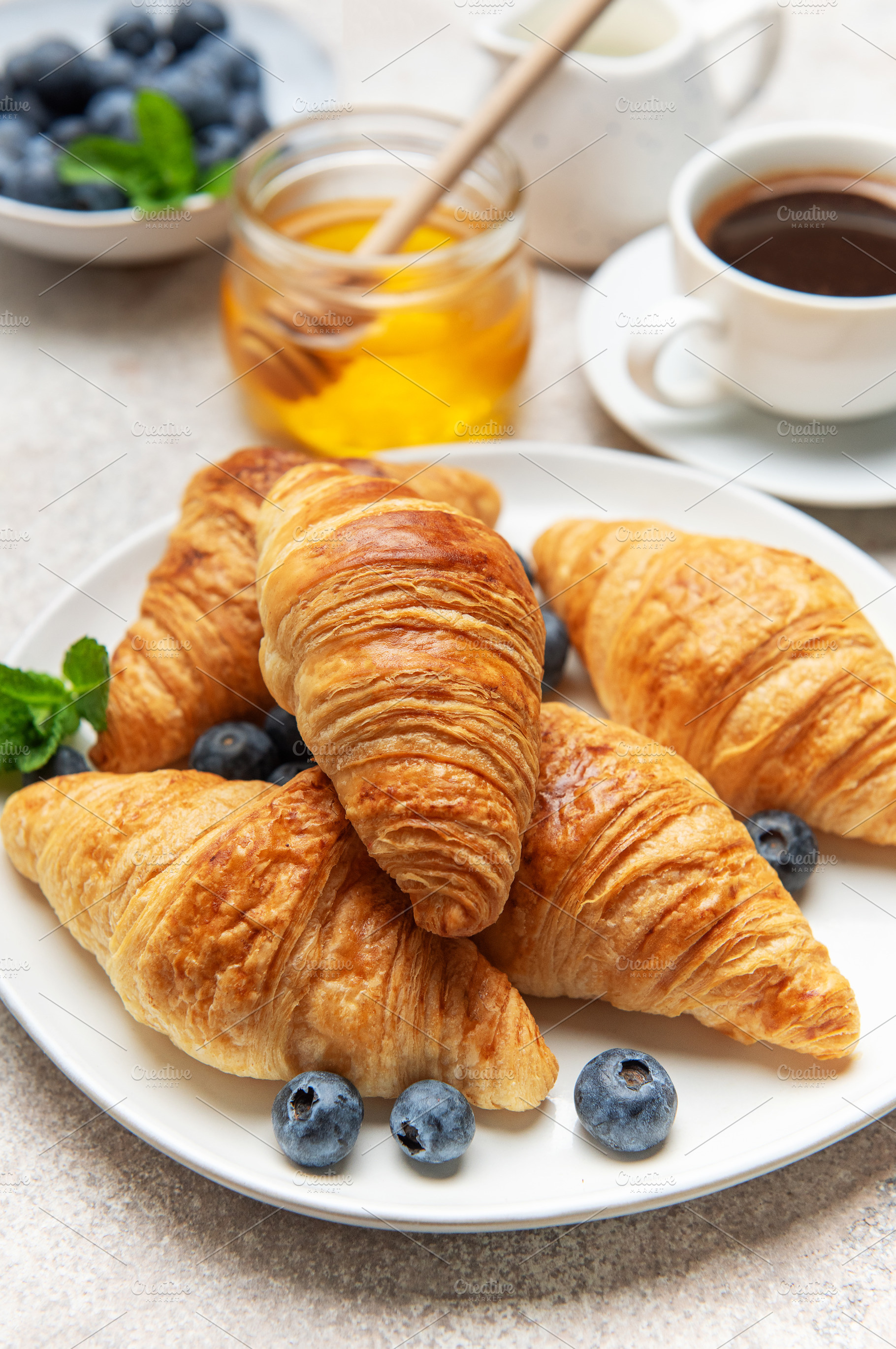 Delicious french croissants with coffee, honey, and fresh bluebe, a Food & Drink Photo by Olena Rudo