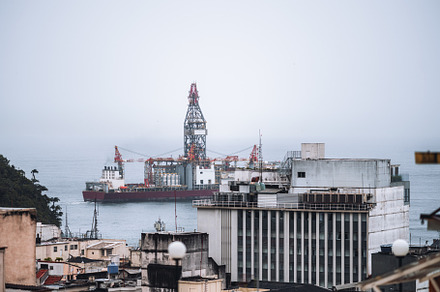 Offshore rig near city buildings, an Industrial Photo by SkyNext