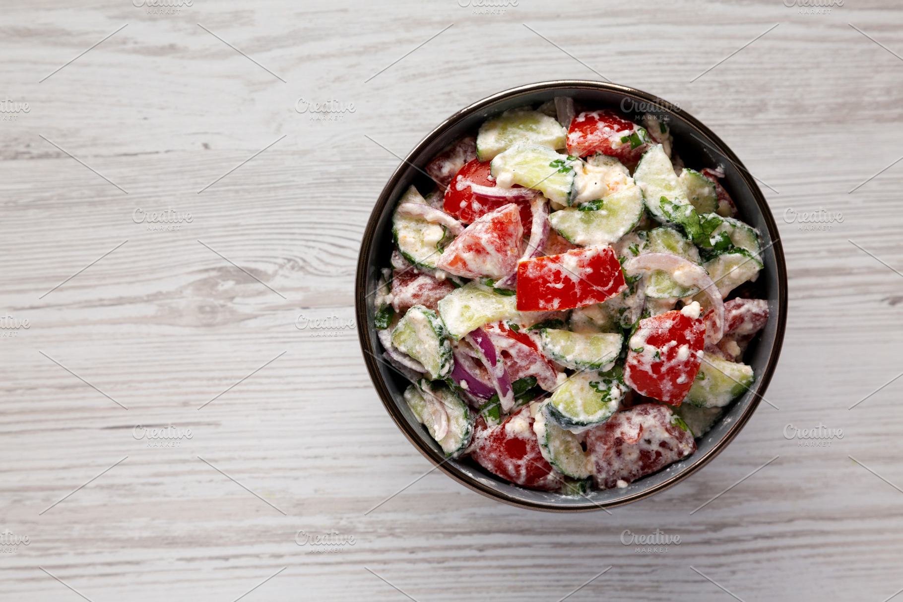 Homemade Tomato Cucumber Feta Salad in a Bowl, top view. Flat la, a Food & Drink Photo by LiudmylaChuhunova