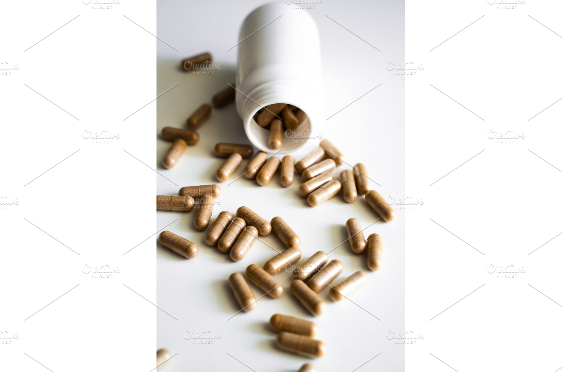 White plastic bottle spilling herbal, a Health & Medical Photo by volodymyrshtun13795