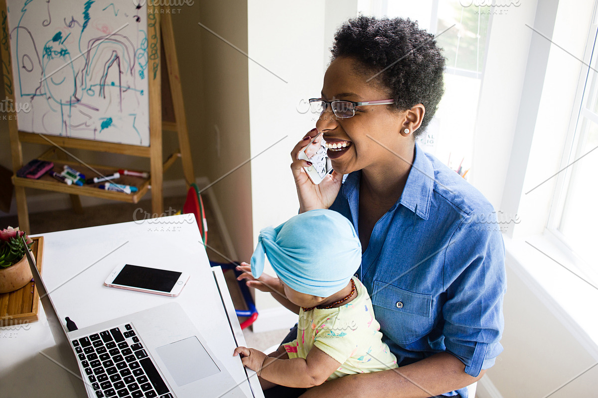 Black Woman On Phone Holding Baby, a Photo by HUNCreative (Photo 1 of 2)