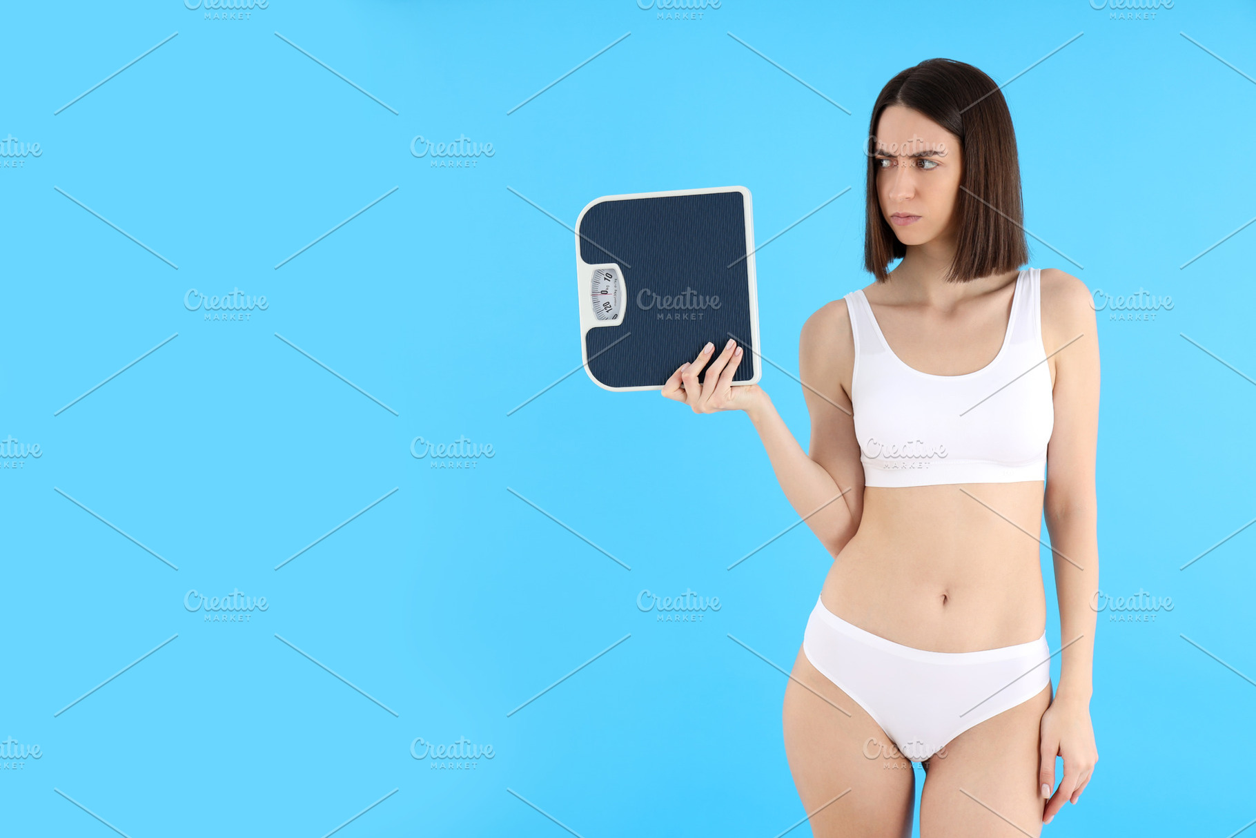 Concept of weight loss with young slim woman on blue background, a Person Photo by AtlasStudio