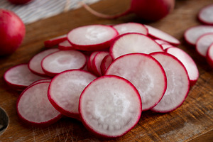Raw Red Radish Slices on a Cutting Board, side view., a Food & Drink Photo by LiudmylaChuhunova