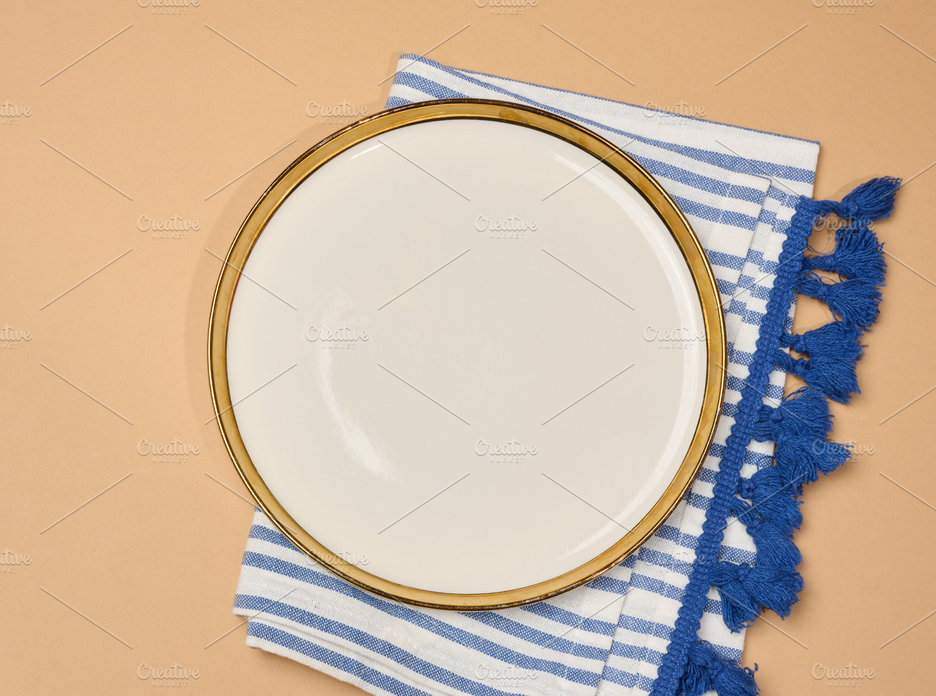 Empty white plate with a gold rim on a striped blue and white na, a Food & Drink Photo by ndanko