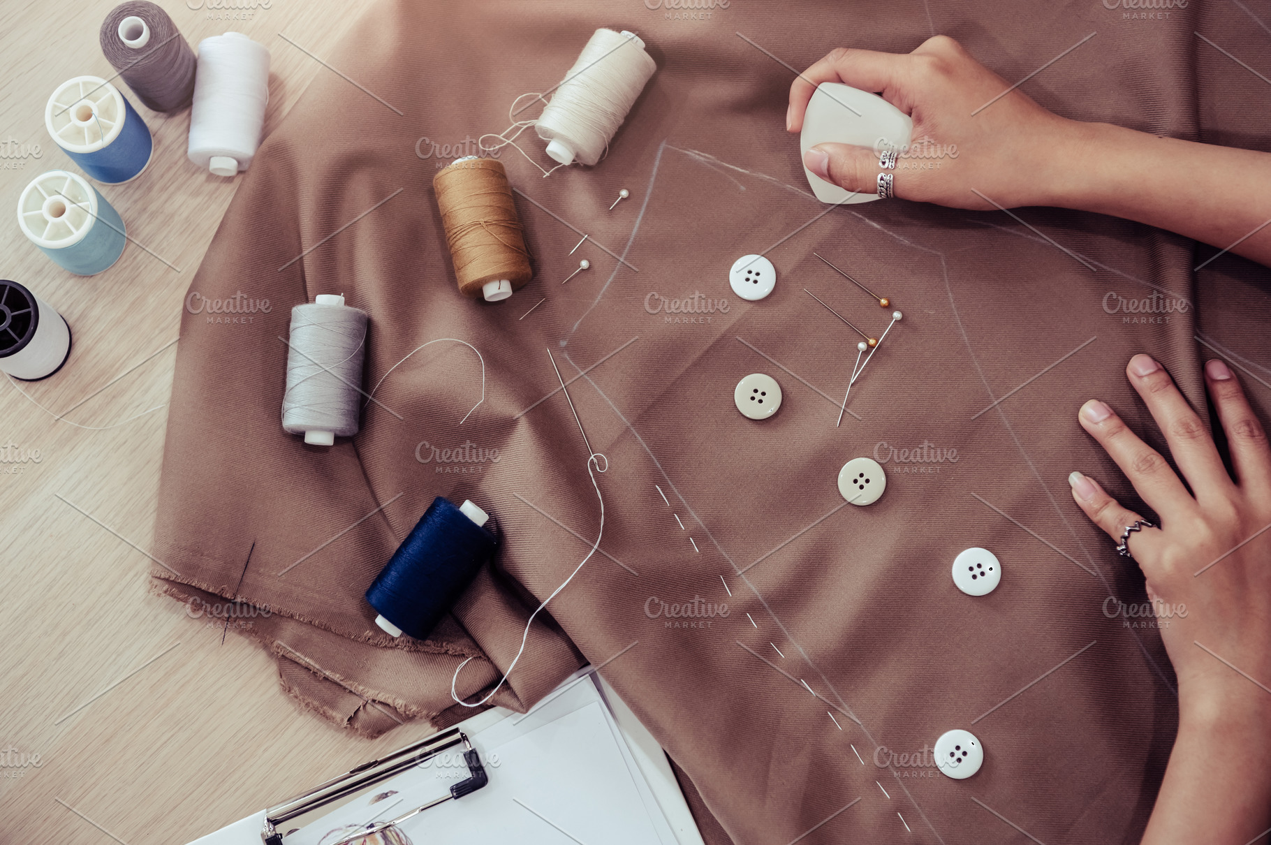 Top view of beautiful dressmaker sewing dress fabric with hand., a Beauty & Fashion Photo by Ministocker