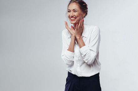 beautiful businesswoman in white blouse and black pants fun laughing and rejoicing at victory against white background in studio, a Person Photo by andreonegin market