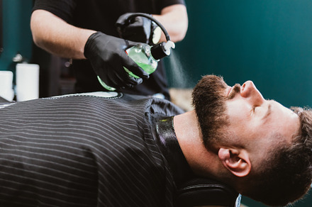 Barbershop male client receives after-shave cologne spray treatm, a Person Photo by progressman