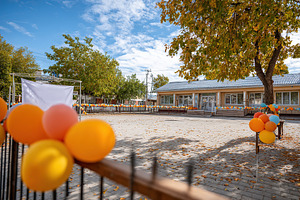 Colorful balloons decorate a festive courtyard during a sunny autumn day, a Photo by AlyaAnd
