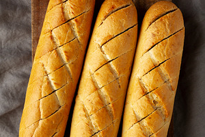 Homemade French Baguette with Garlic Filling on a wooden board,, a Food & Drink Photo by LiudmylaChuhunova
