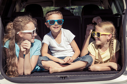 Happy kids sitting in the car containing car, child, and family