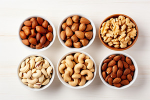 Bowls of hazelnut, cashew and almonds butter on wooden background, a Food & Drink Photo by AlyaAnd