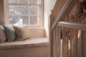 Cozy window seat creating a warm and inviting atmosphere inside a home while sn, a Photo by Studio ANNA