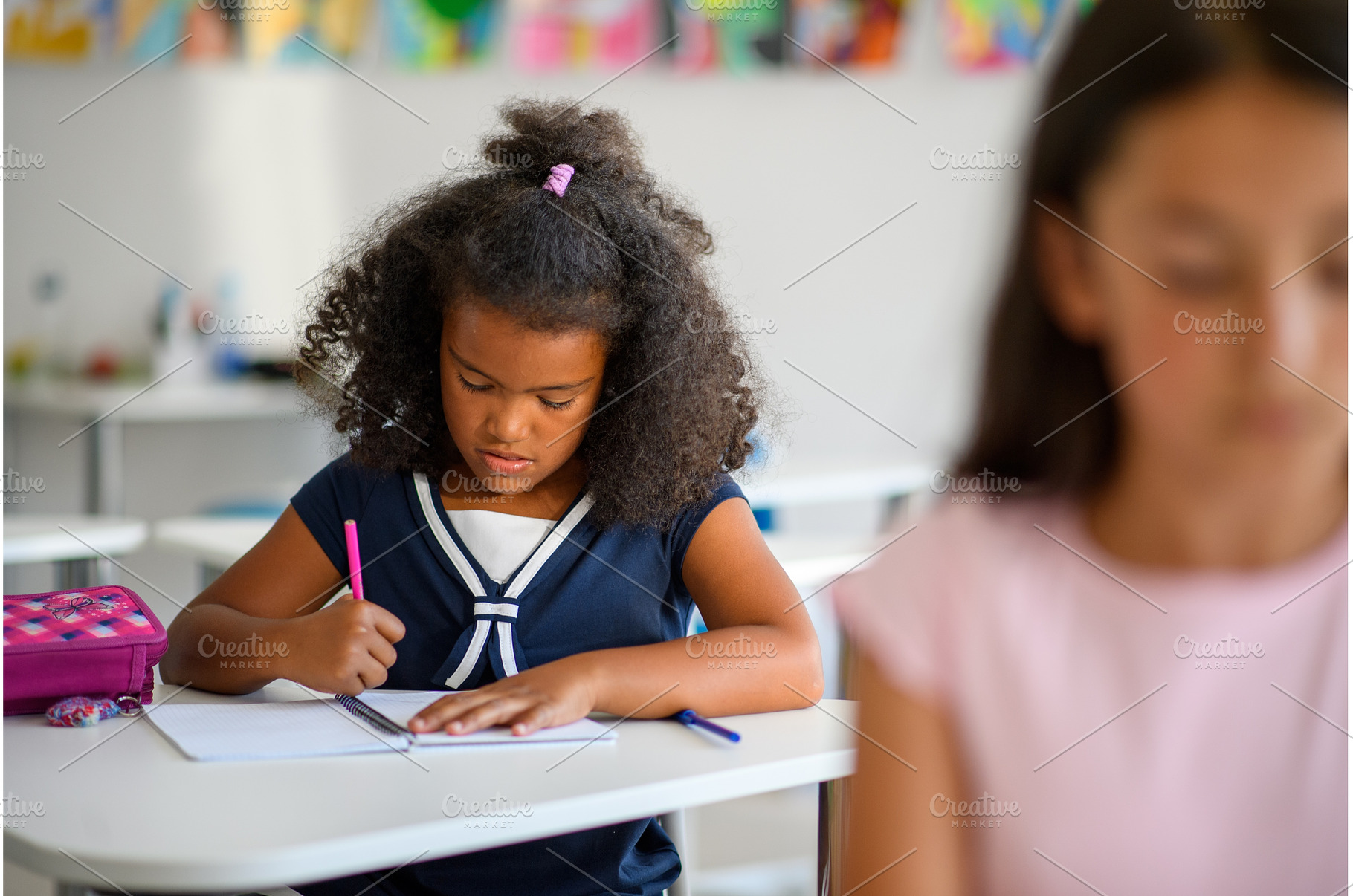 Focused schoolgirl writing notes in, a Person Photo by HalfPoint