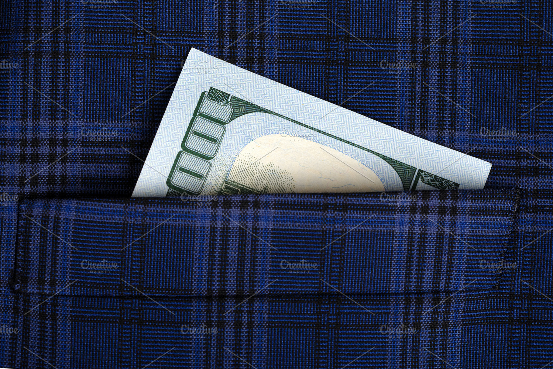 Close-up of a US hundred dollar bill partially visible in a blue plaid pocket,, a Business Photo by Ales Munt