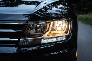 Car Headlight Turned On Close Up on Road at Dusk, a Transportation Photo by Red Hot Chili Pepper Shop