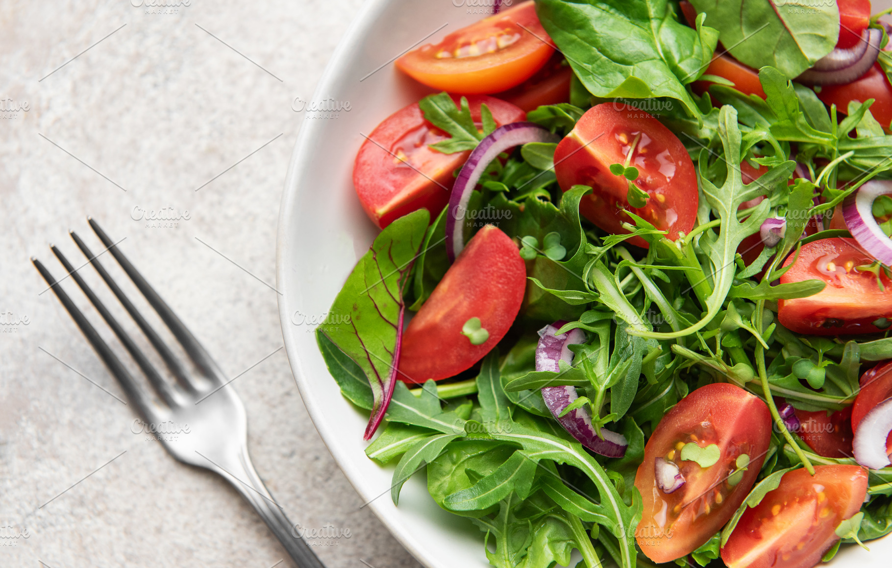 Fresh vegan salad with arugula, tomatoes, and red onion, a Food & Drink Photo by Olena Rudo