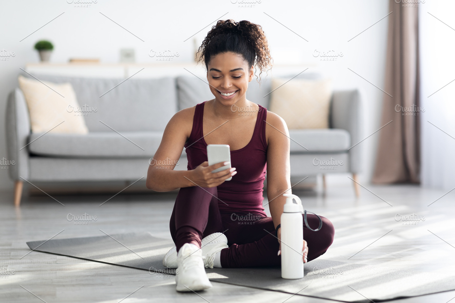 Happy athletic black woman using mobile phone while exercising, a Photo by Prostock-Studio